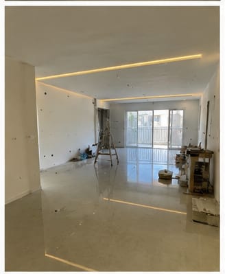 סלון לאחר שיפוץ עם תאורה שקועה וריצוף בהיר